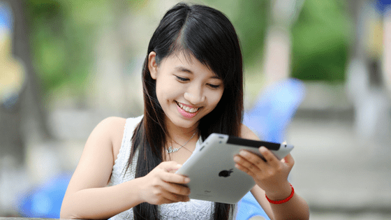 a chinese woman chatting with singles on her tablet