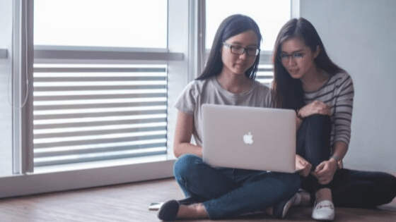 two girls working on a laptop