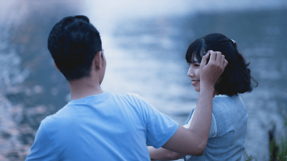 a boy tucking a girl's hair