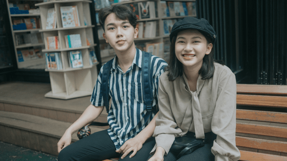 two chinese friends sitting on a bench