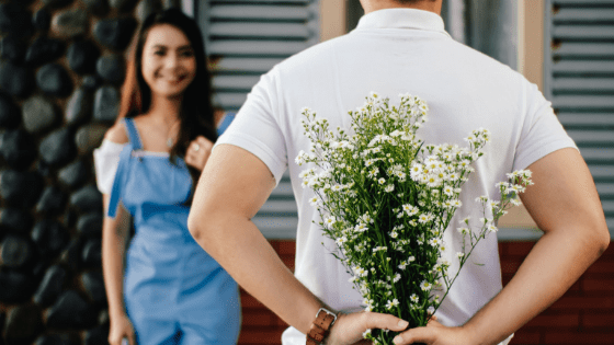 a man about to give a girl flowers